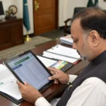 Pakistani government official reviewing household socioeconomic survey data on tablet computer, NSER administration office, d